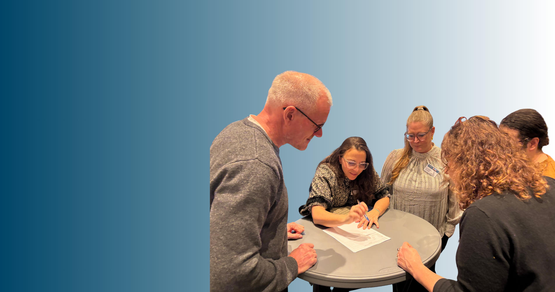 Læger og sygeplejesker der står rundt om et bord 